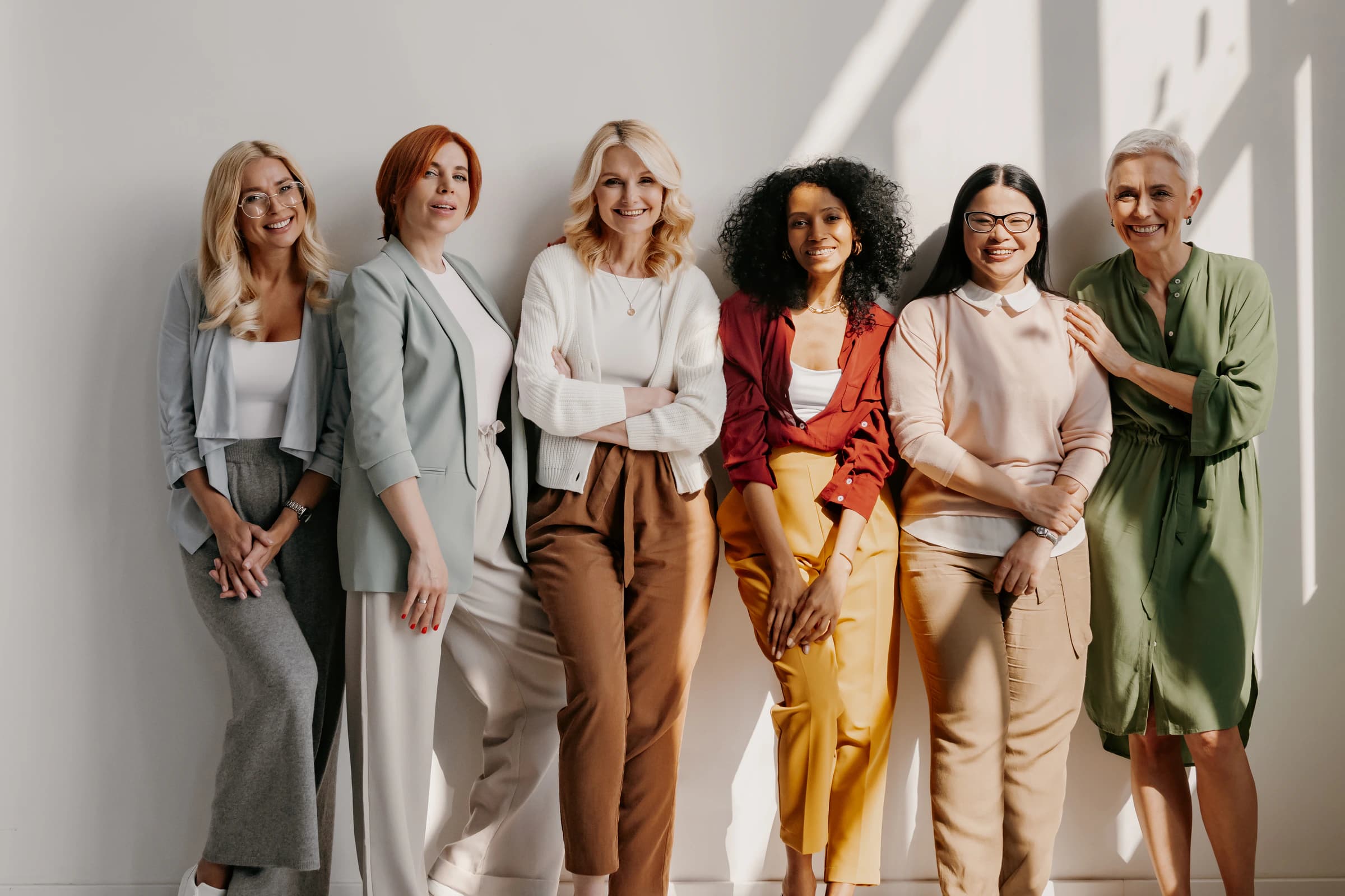 A diverse group of women standing together in warm natural light